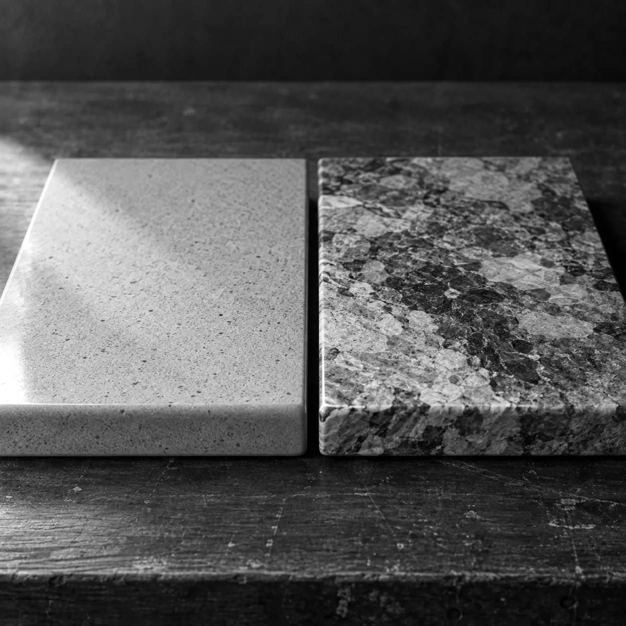 Render of two kitchen countertop samples, a fine even speckle like quartz on the left and large mixed crystals like granite on the right.